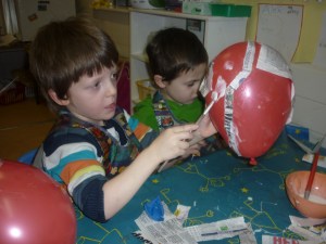 The children are right in the middle of a fantastic learning plan, exploring space. They have been learning the names of all the planets and  have made a space centre to play in. Here are Jack and Dathan using papier mache to make models of the planets..........